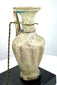 Ancient Roman pale green glass vessel featuring pronounced vertical ribbing, a slender cylindrical neck, and applied blue-green decorative trails.