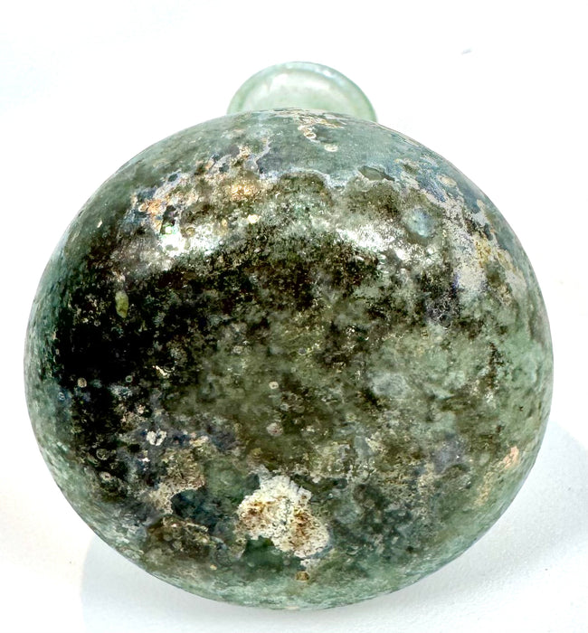 Eastern Mediterranean Roman glass unguentarium featuring a slender neck, rounded shoulders, and extensive natural surface patination.