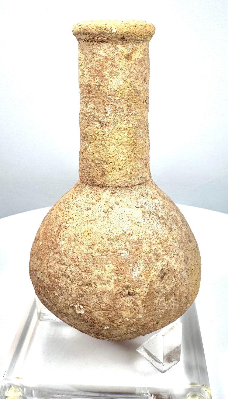 Roman stone perfume bottle featuring a rounded lower chamber, recessed neck band, and natural beige to sandy-brown coloration.
