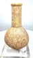 Roman stone perfume bottle featuring a rounded lower chamber, recessed neck band, and natural beige to sandy-brown coloration.