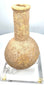 Roman-period carved stone vessel exhibiting extensive mineral deposits, surface abrasions, and natural irregularities across its bulbous body.