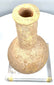 Ancient Roman Imperial unguentarium with a long cylindrical neck, pronounced rounded shoulders, and coarse granular stone texture.