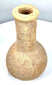 Ancient Roman stone unguentarium featuring a thickened circular lip, narrow opening, and visible weathering along its elongated neck.