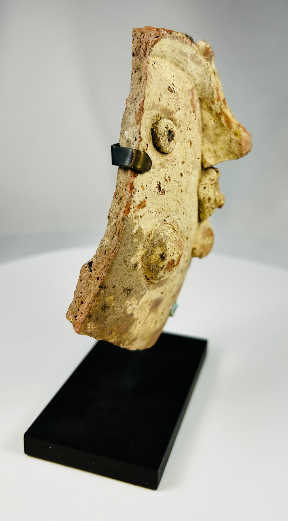 Classical theater mask fragment in terracotta reflecting expressive Greek and Roman dramatic traditions.