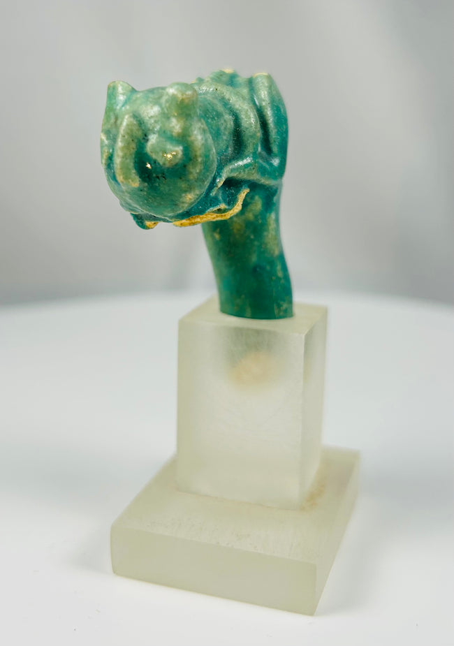 Late Period Egyptian faience fragment depicting a stylized cat head on vessel handle.