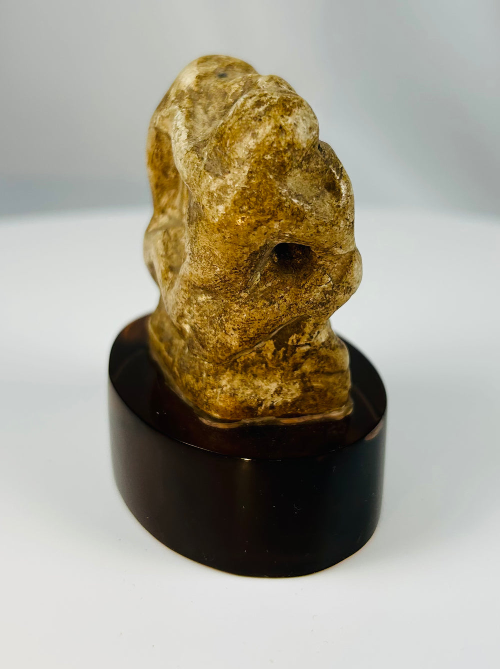 Late Period Egyptian limestone baboon votive figure mounted on display stand.