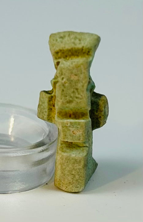 Ancient Egyptian Bes amulet with pale green glaze and suspension hole.