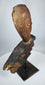 Southeast Asian ritual wood carving fragment featuring expressive almond-shaped eyes and angular nose