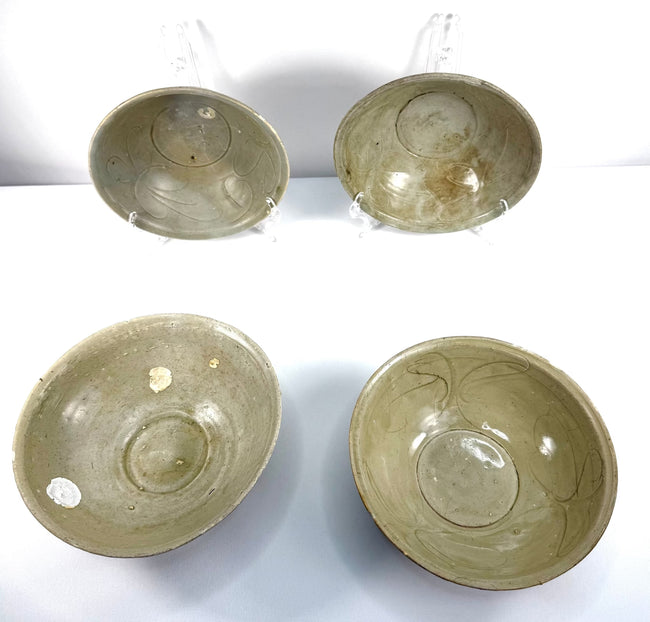 Group of four 12th-century Song Dynasty celadon bowls from the Jepara Shipwreck, displaying traditional Chinese ceramic craftsmanship, incised patterns, and preserved barnacle accretions.