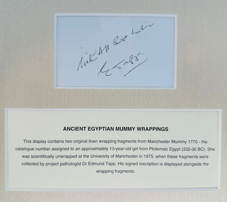 Handwritten inscription above an identification panel describing the history of the attributed Egyptian mummy wrappings.
