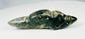 Mesoamerican greenstone pendant featuring reclining animal form and natural patina