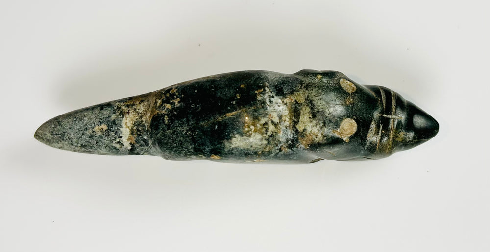 Ancient greenstone animal effigy with engraved facial features and smooth finish