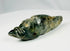 Mesoamerican greenstone ornament with stylized animal design and mineral mottling