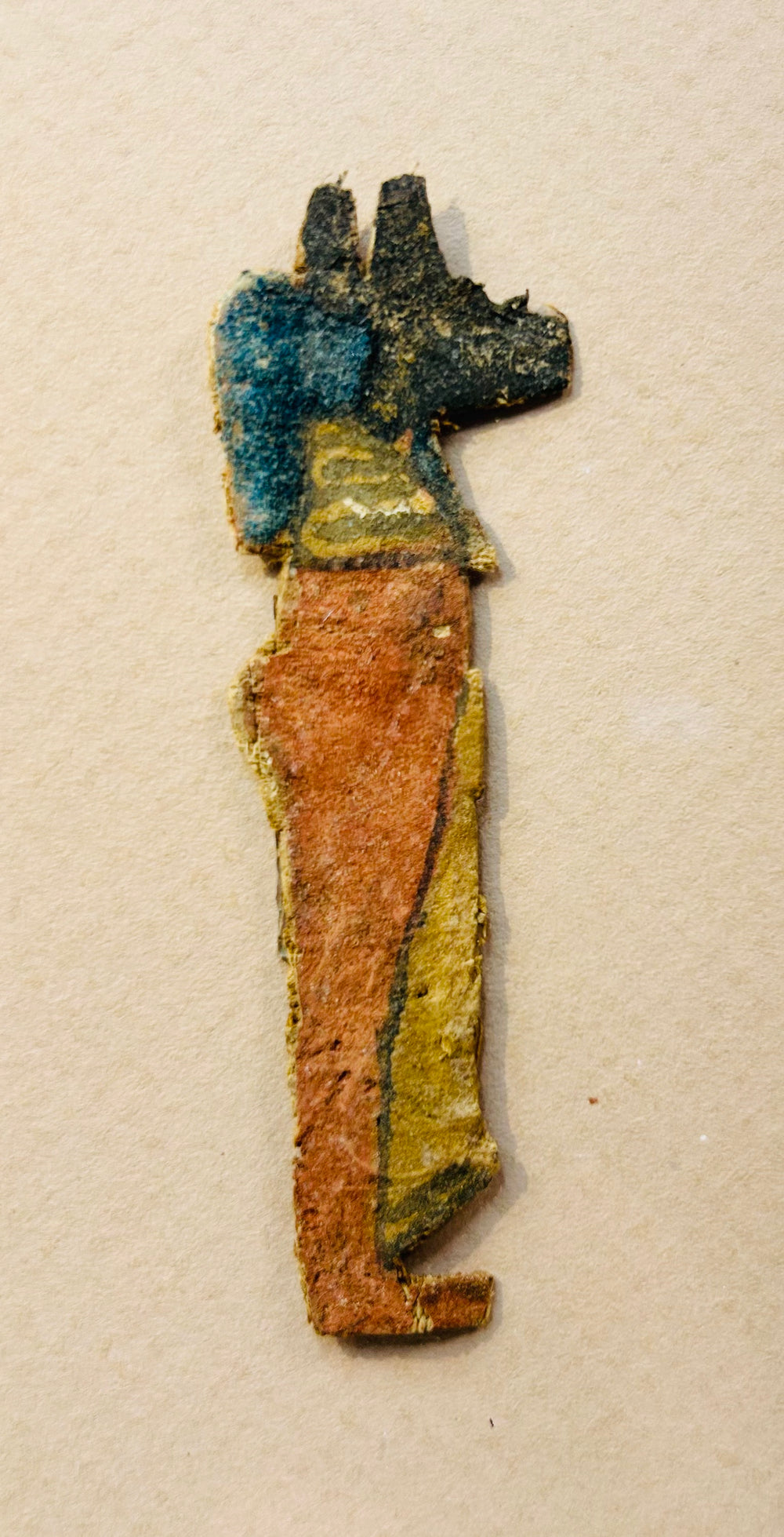 Ancient Egyptian coffin fragment featuring Anubis with preserved pigments