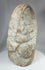 Ancient limestone anthropomorphic sculpture with minimal facial detail and weathering