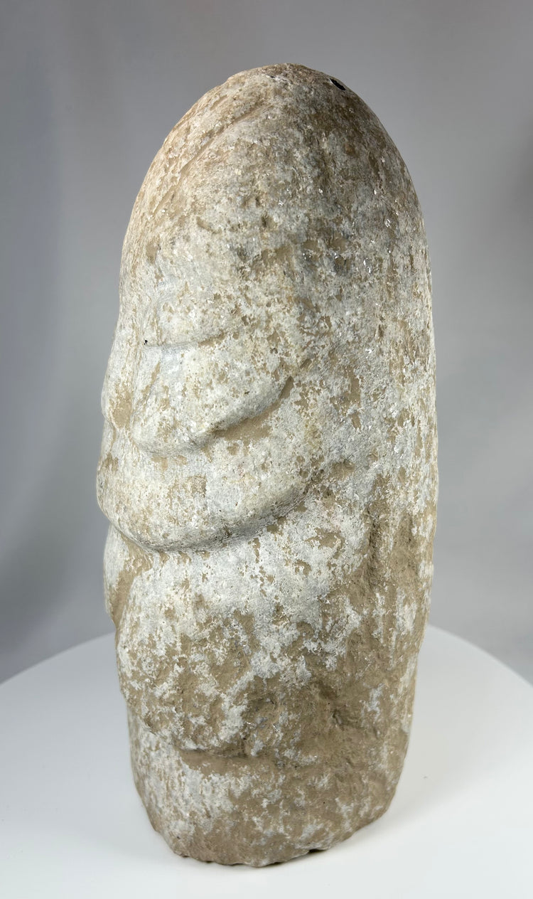Near Eastern stone idol with folded arms and mineral encrustation