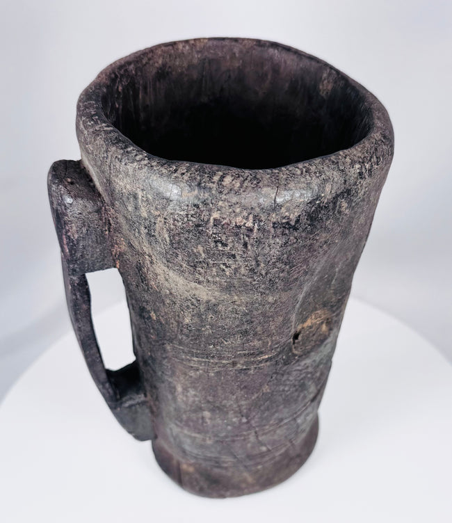 Rustic Tibetan carved hardwood container with integral handle and aged utilitarian surface