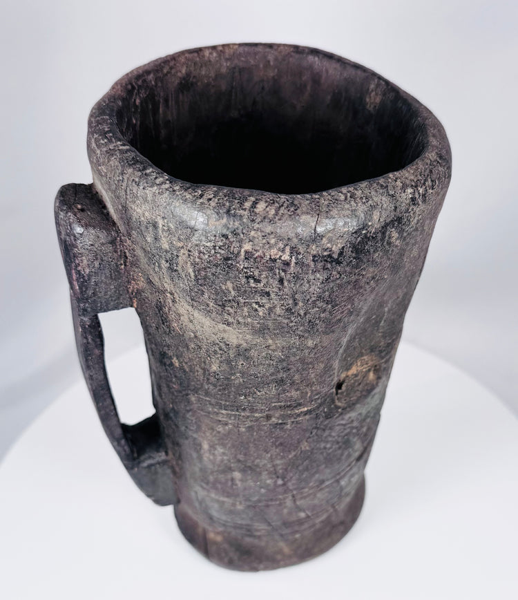 Rustic Tibetan carved hardwood container with integral handle and aged utilitarian surface
