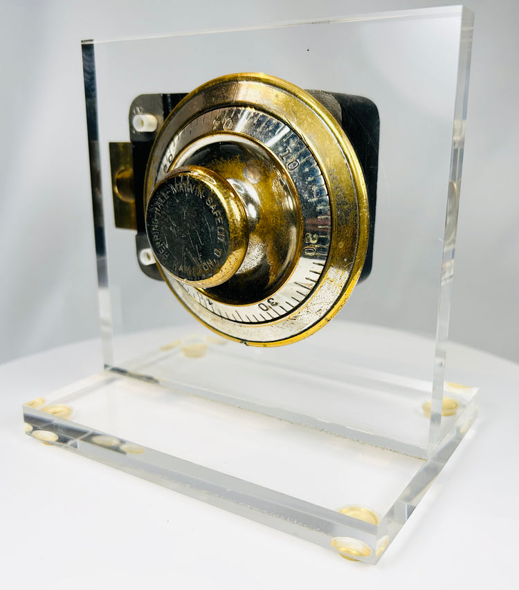 Vintage safe combination lock mechanism showing brass dial and inner workings