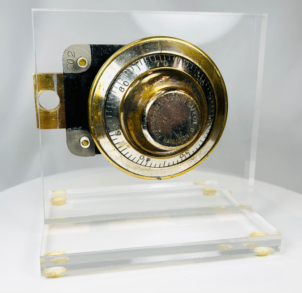 Vintage safe combination lock with visible gearing and acrylic mount display