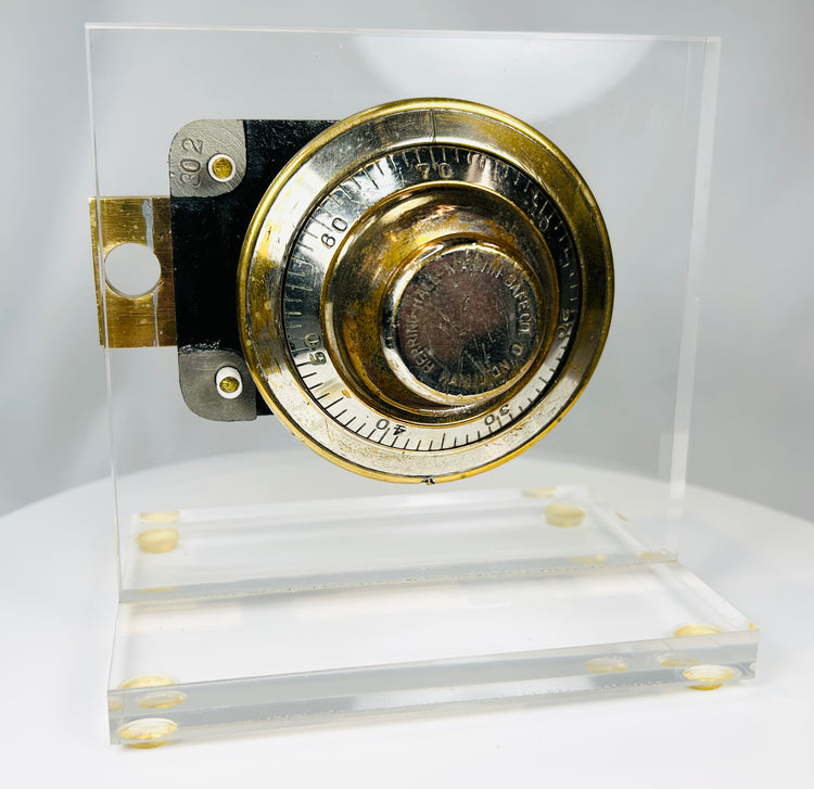 Vintage safe combination lock with visible gearing and acrylic mount display
