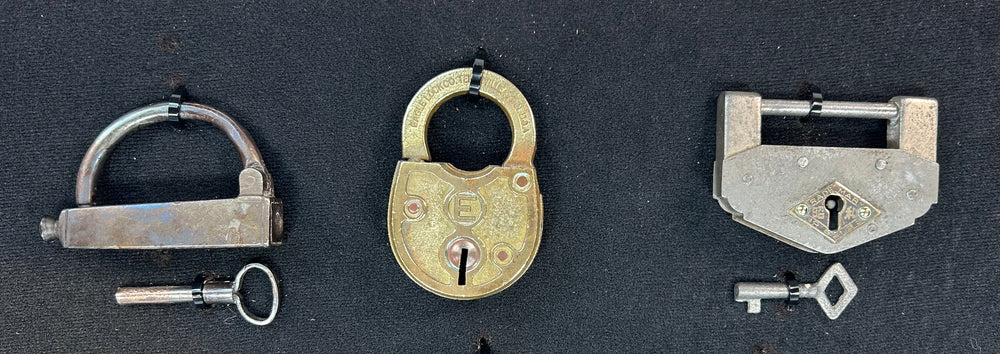 Framed antique lock collection with brass, iron, and steel padlocks