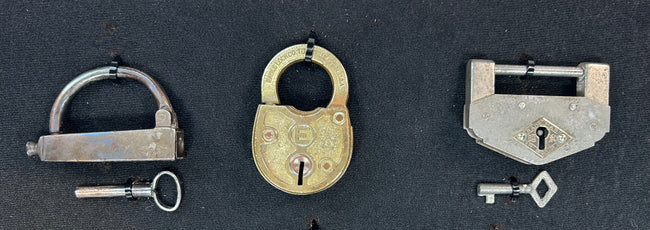 Framed antique lock collection with brass, iron, and steel padlocks
