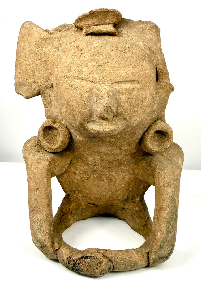 Pre-Columbian Mesoamerican terracotta seated human figurine, circa 200–800 CE, featuring an elaborate headpiece and circular ear ornaments.