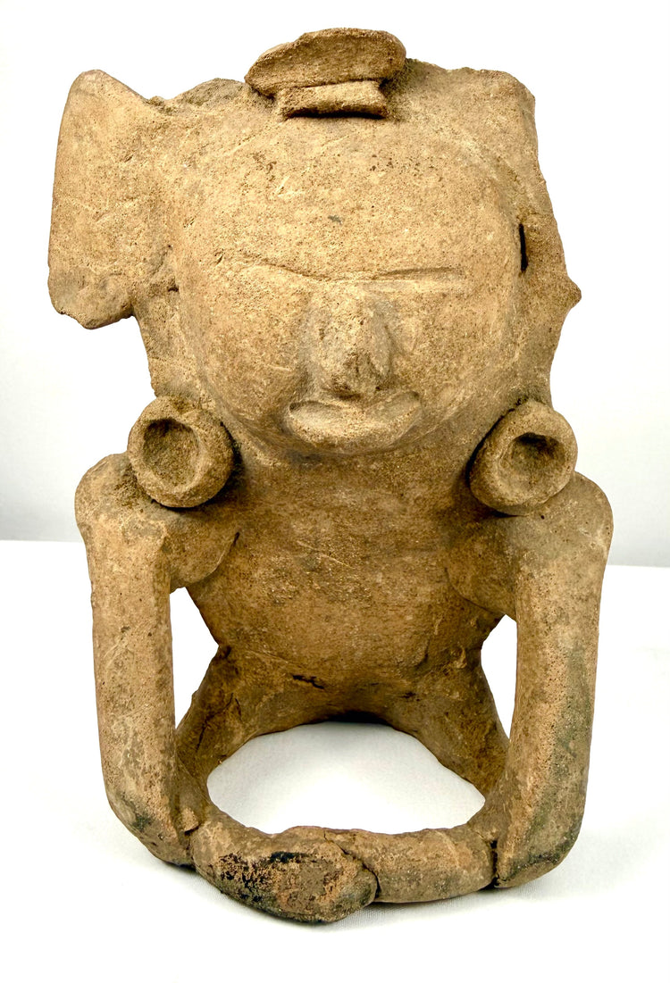 Pre-Columbian Mesoamerican terracotta seated human figurine, circa 200–800 CE, featuring an elaborate headpiece and circular ear ornaments.