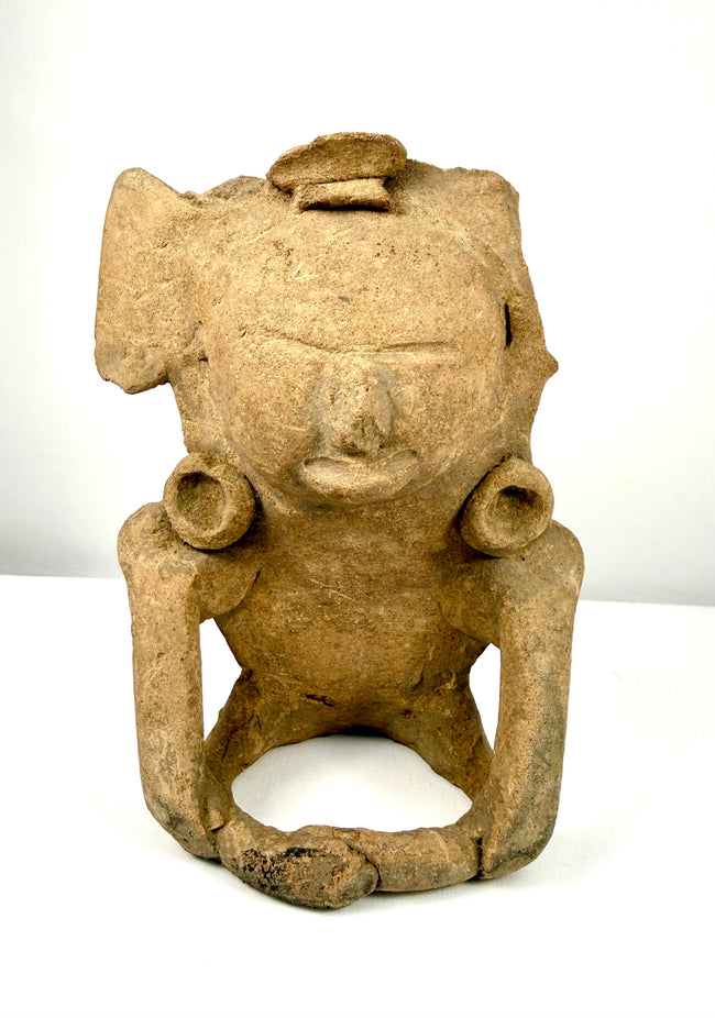 Ancient Mesoamerican ceramic figurine depicting a seated human figure with elongated arms, stylized facial features, and traditional terracotta craftsmanship.