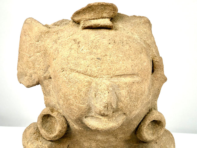 Pre-Columbian ceramic sculpture featuring a hollow opening at the rear, traditional hand-modeled construction, and natural mineral deposits.