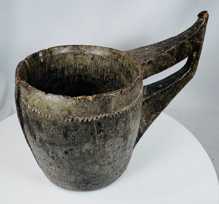 Ethnographic hardwood vessel with carved triangular motifs and integrated handle construction