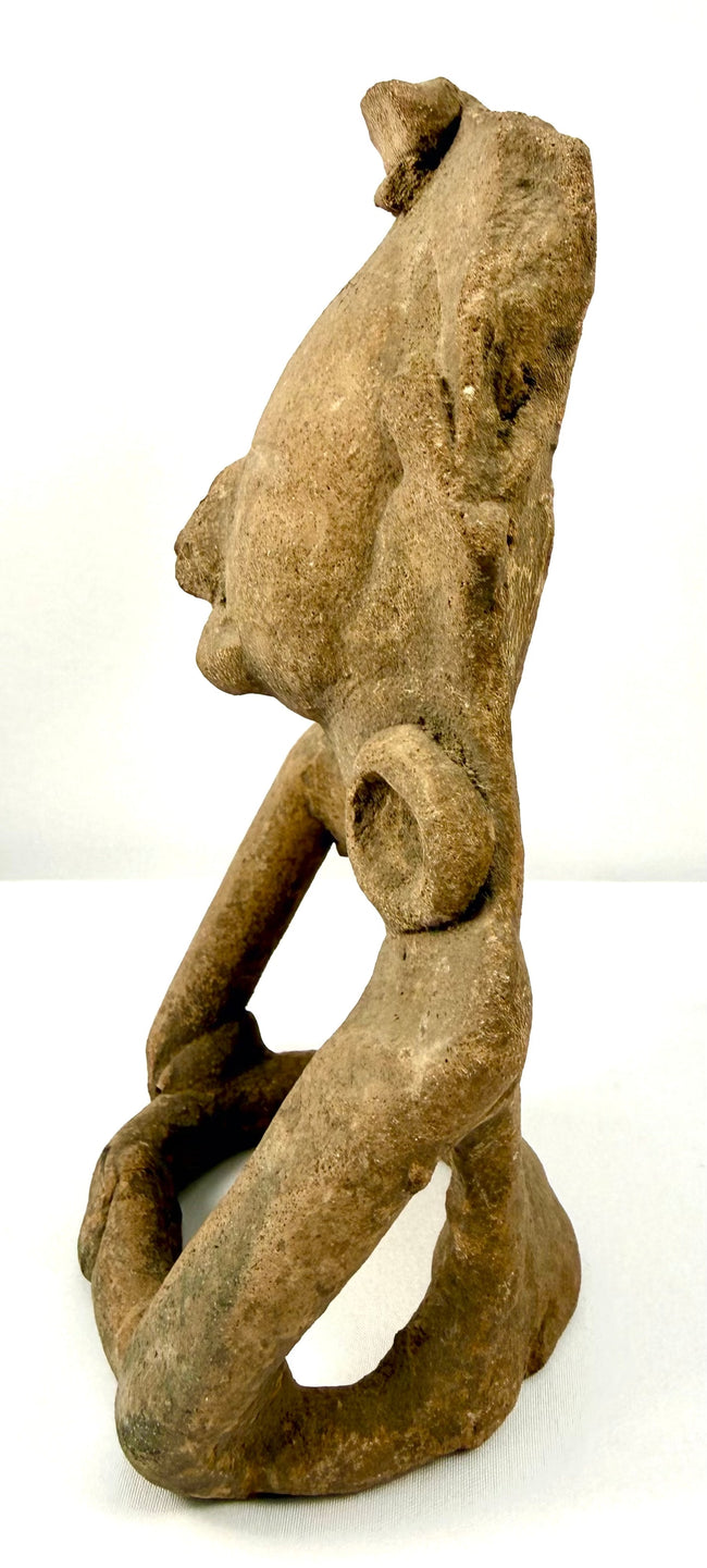 Pre-Columbian terracotta sculpture displaying a broad rounded face, prominent nose, sculpted lips, and large circular ear ornaments.