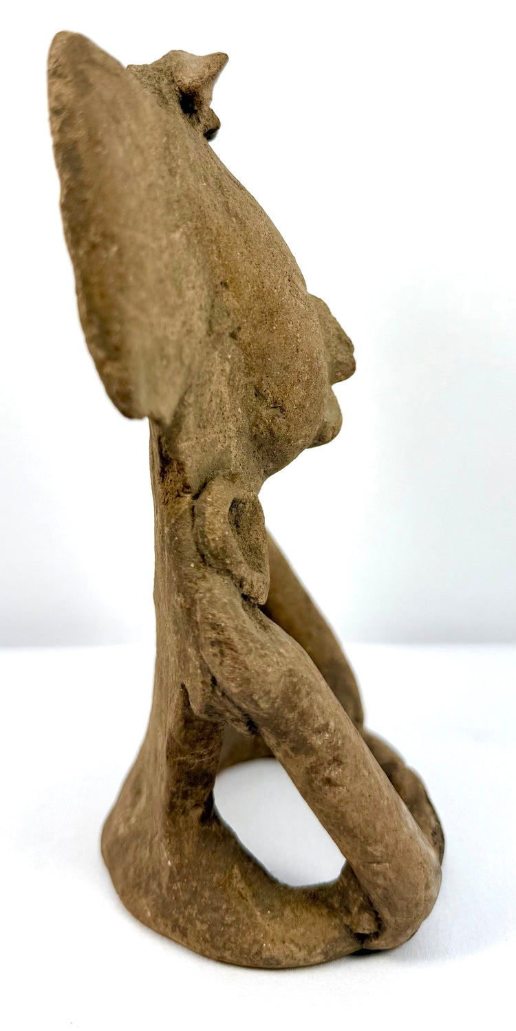 Mesoamerican anthropomorphic terracotta figurine displaying symmetrical ear ornaments, an elaborate headpiece, and a composed facial expression.