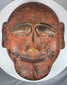 Traditional tribal wooden mask displaying abstract facial forms and authentic aged wear