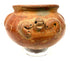 Ancient American terracotta ceramic vessel featuring a rounded profile, ornamental relief details, scattered surface abrasions, and darker areas of patination.