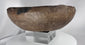 Ancient ceramic serving vessel with dark mineral deposits and thick reinforced rim