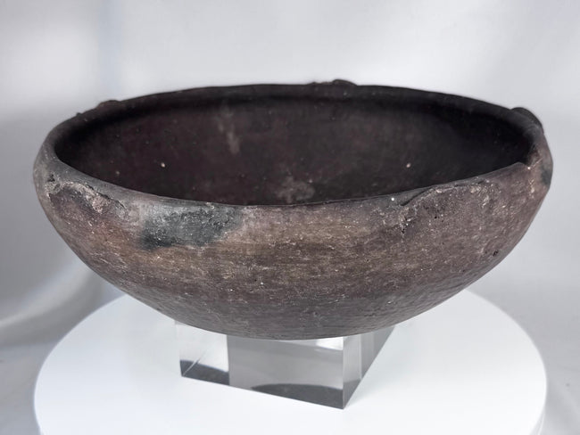 Pre-Columbian ceramic bowl with dark firing coloration and sculptural rounded profile