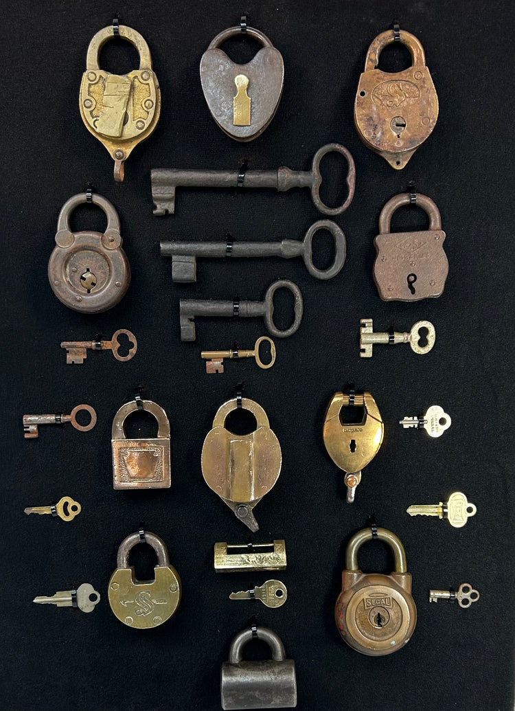Curated lock and key collection with skeleton keys and warded locks in museum-style frame