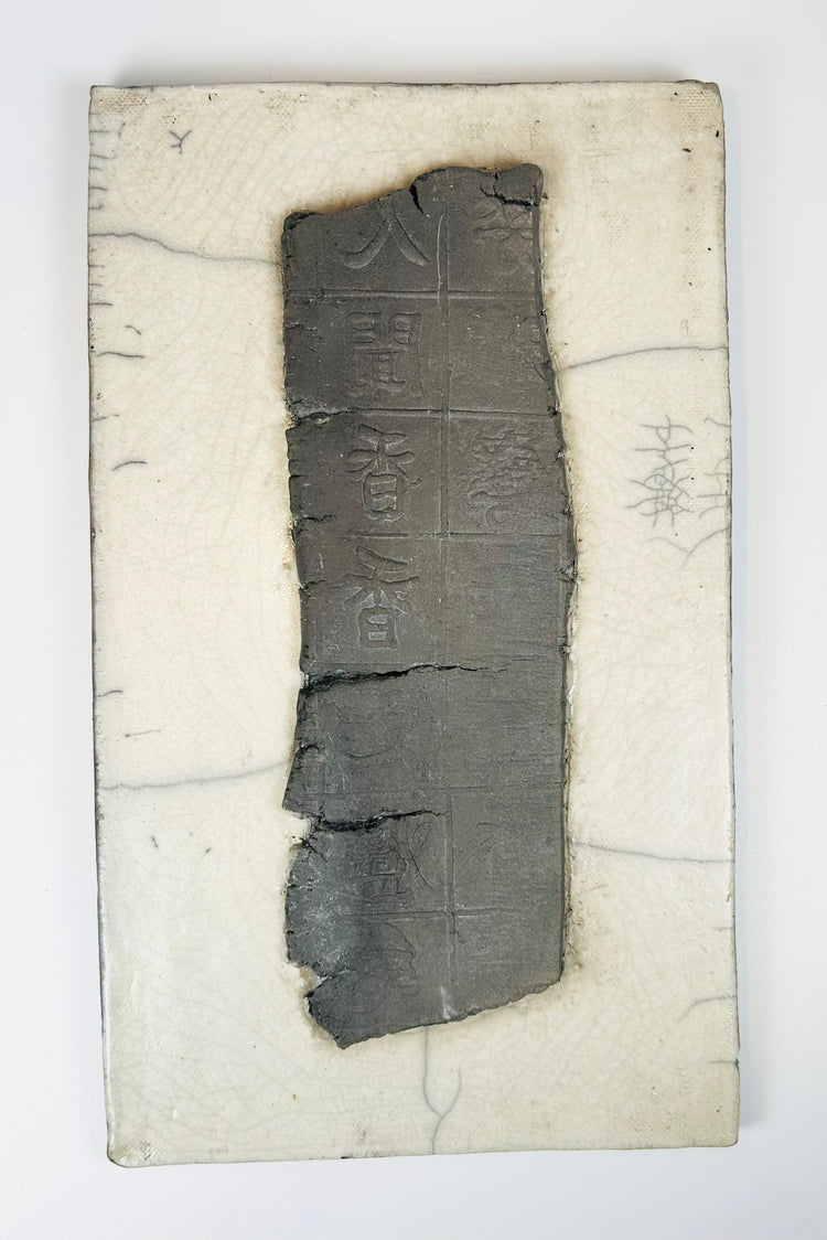 Front view of Chinese ceramic fragment showing carved panels with symbolic inscriptions and aged surface