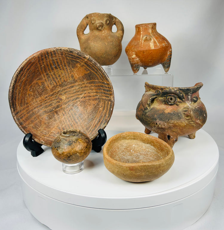 Group of ancient Mesoamerican and South American ceramic vessels with varied forms and aged patina