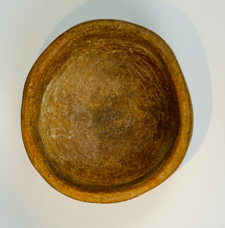 Pre-Columbian ceramic bowl with shallow form and worn interior surface showing age and use