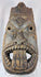 Hand-carved West African wooden ritual mask featuring recessed eyes, carved teeth, and aged patina.