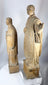 Antique wooden religious statues featuring a bearded cleric and youthful saint holding a symbolic attribute.