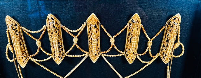 19th-century Tibetan Tantric ritual bone apron (rus gyan) displayed in black frame, featuring six carved bone plaques depicting Chakrasamvara deities, intricate bead lattice, cotton backing, and natural pigments — sacred Himalayan Buddhist ceremonial garment.
