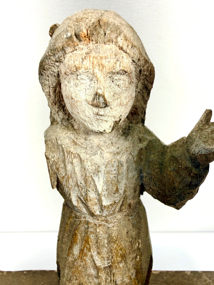 Detail portrait of small central child Jesus figure with simplified features and chipped paint