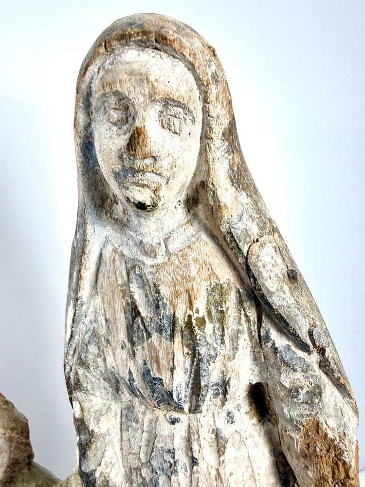 Detail of female figure's hooded veil with heavily distressed paint revealing wood texture