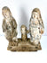 High-angle view of aged wood religious statues showing rough texture and connected hands