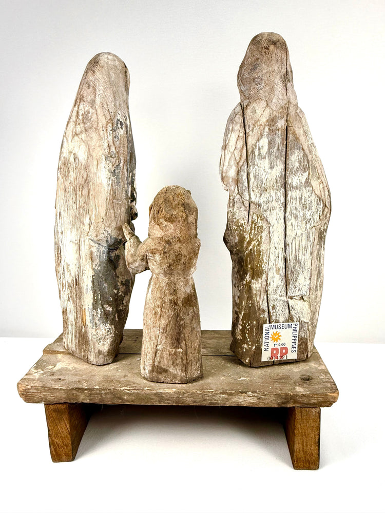 Rear view of antique wooden saints displaying National Museum Philippines sticker and grain