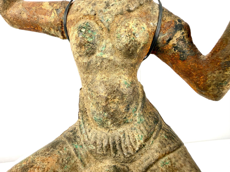 Close-up of textured bronze torso with oxidation and support wire